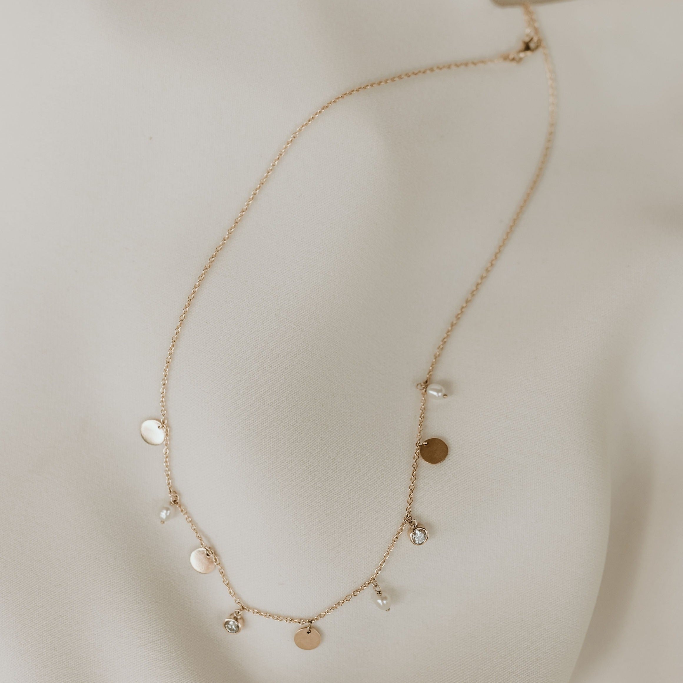 18ct yellow gold multi-charm necklace, customised with diamonds and pearls.