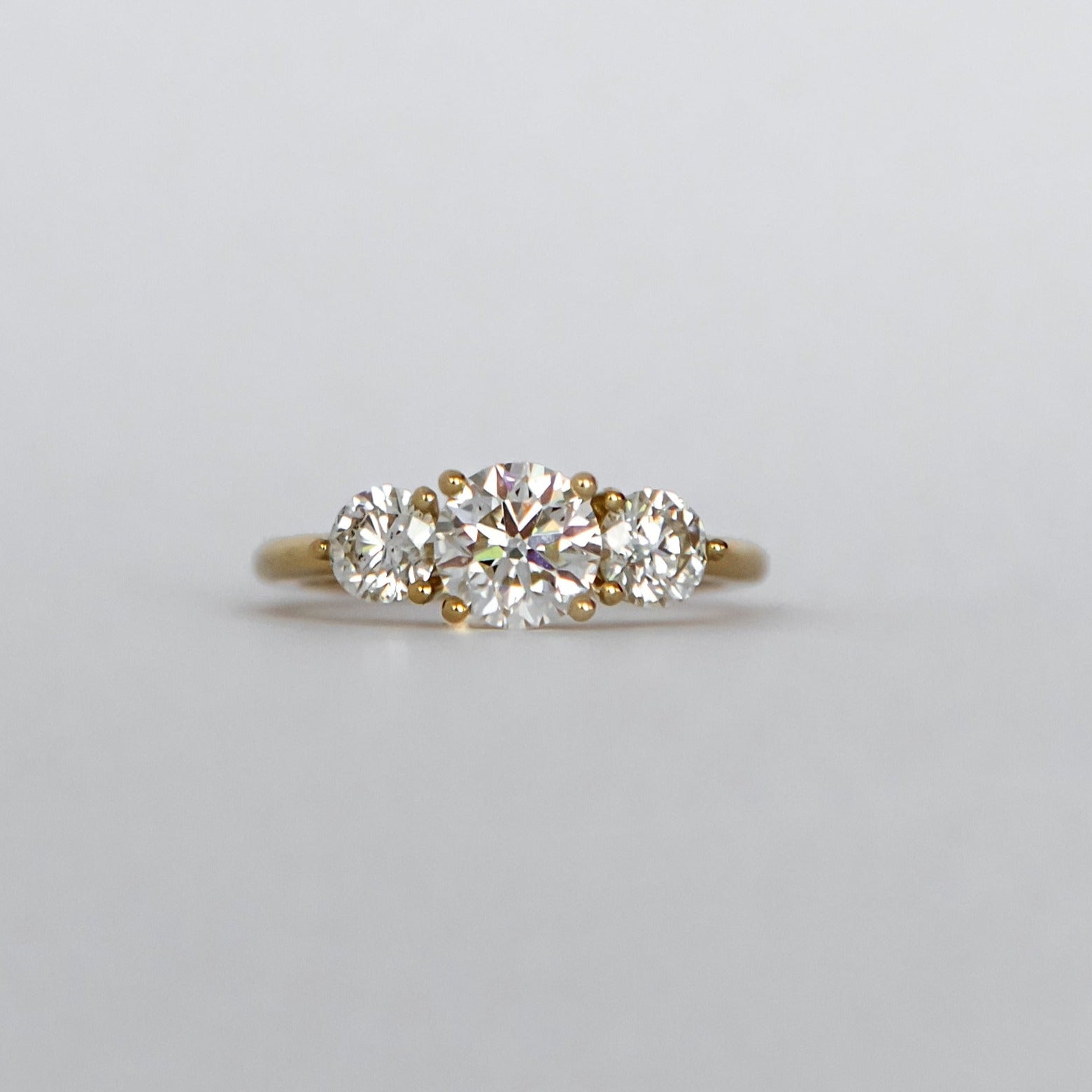 18ct yellow gold trilogy ring with 0.90ct oval cut diamond as the centre stone flanked by two smaller diamonds.