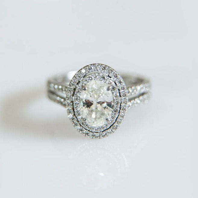 18ct white gold solitaire engagement ring with 0.90ct oval cut diamond as the centre stone surrounded by a double halo and split diamond band