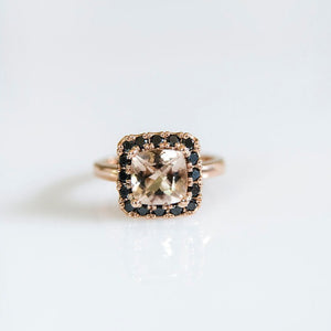 18ct rose gold ring with morganite as the centre stone and a halo of black diamonds surrounding it.