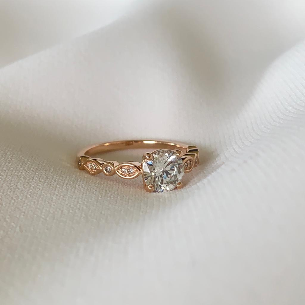 18ct rose gold solitaire ring with 0.03ct round brilliant cut diamond in a scalloped diamond band.