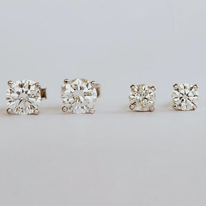 a pair of diamond stud earrings with a total Weight of 1,2ct claw set in 18ct Yellow Gold with custom push on butterflies